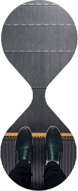 Eine Person steht auf einer Rolltreppe und trägt eine schwarze Hose und schwarze Schuhe. Klebelösungen von Abifor finden Anwendung im Bereich der Förderbänder.