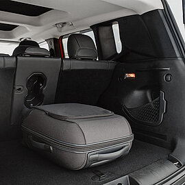 Ein grauer Koffer liegt im Kofferraum eines Autos | Abifor