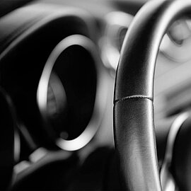 Ein Close-up von einem schwarzen Lenkrad aus Leder, einem Anwendungsbeispiel von thermoplastischem Klebstoff. | Abifor