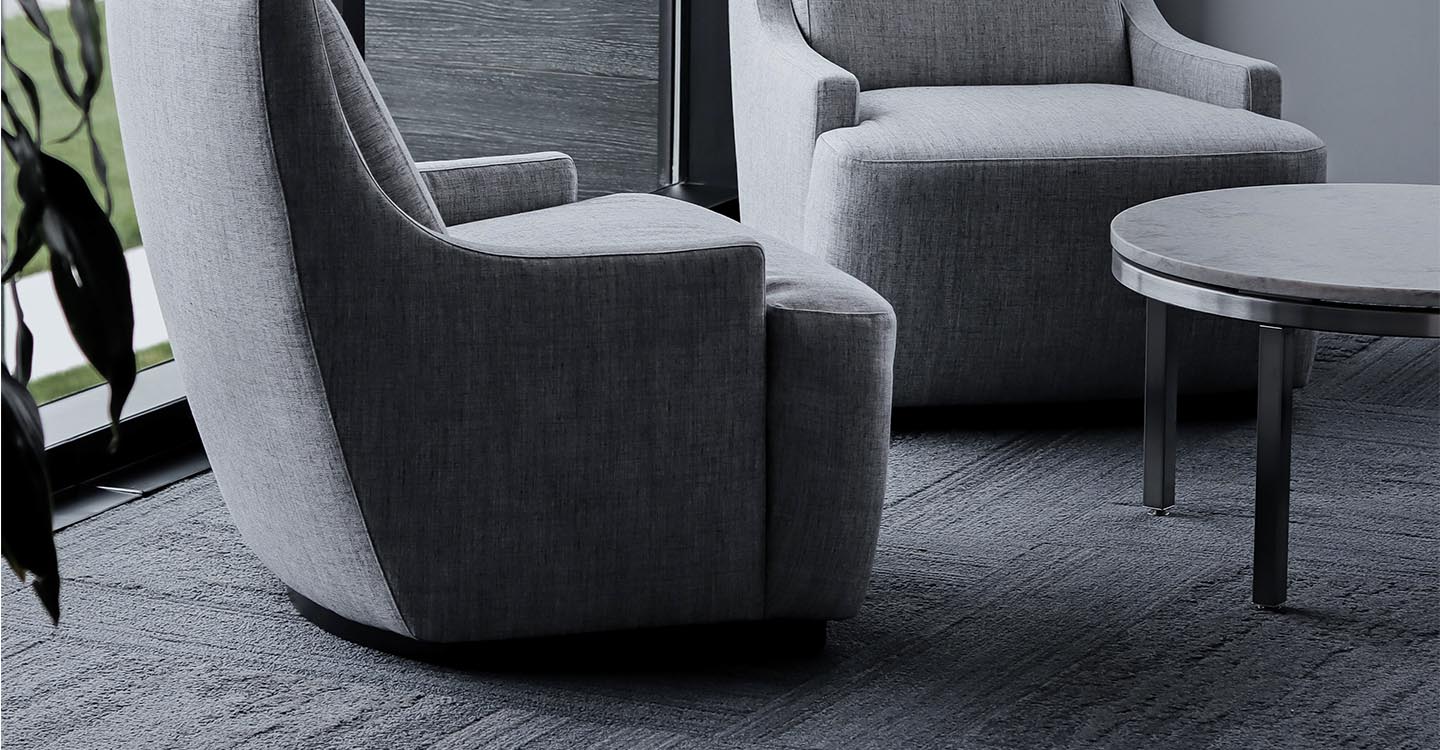 Zwei graue Stühle in einem Raum mit grauem Teppich | Abifor